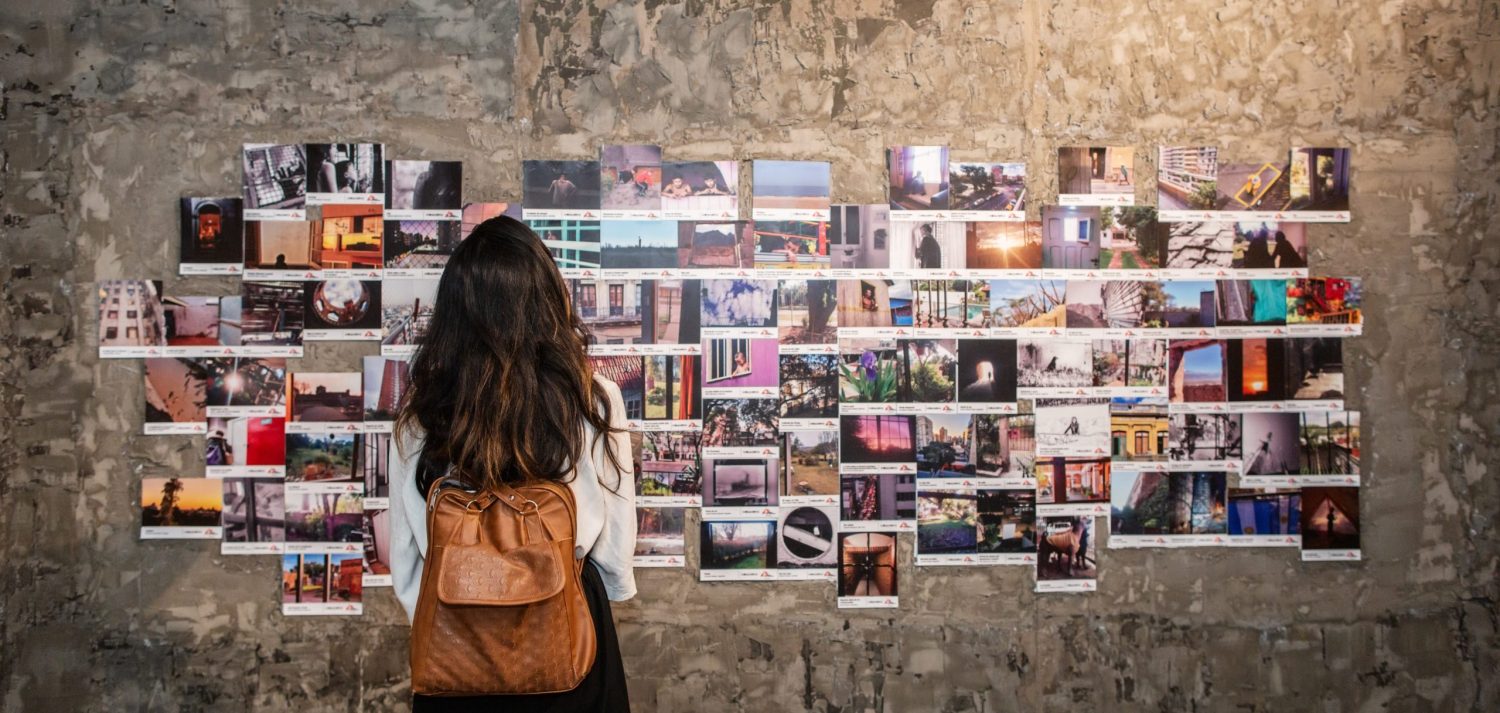 Mujer contempla el muro de fotografías de la exposición de MSF en Colombia.